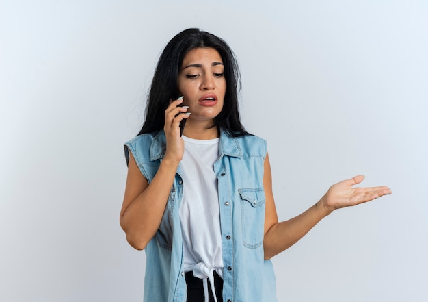 Foto gratuita mujer caucásica joven disgustada habla por teléfono mirando hacia abajo