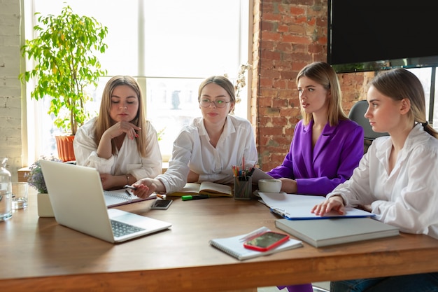 Mujer caucásica joven de negocios en la oficina moderna con equipo