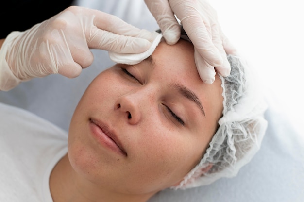 Mujer caucásica pasando por un procedimiento de microblading