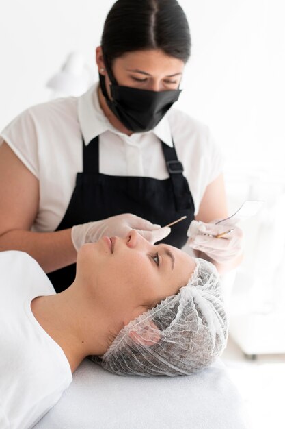 Mujer caucásica pasando por un procedimiento de microblading