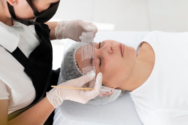 Mujer caucásica pasando por un procedimiento de microblading