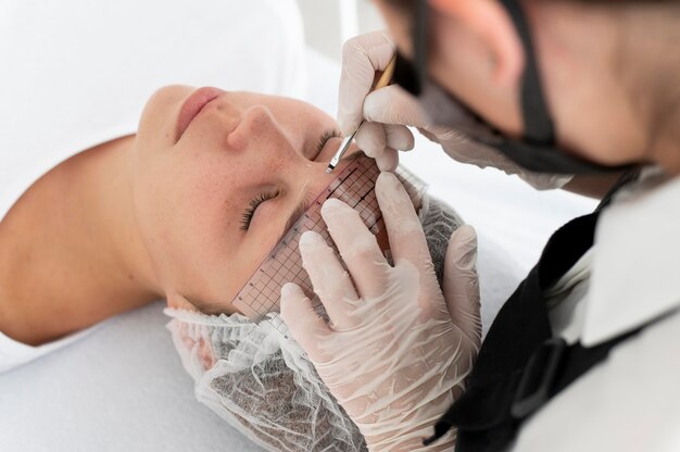 Mujer caucásica pasando por un procedimiento de microblading