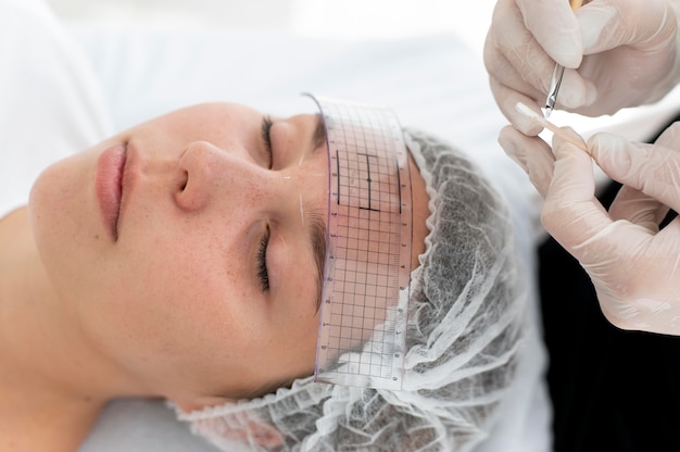Mujer caucásica pasando por un procedimiento de microblading