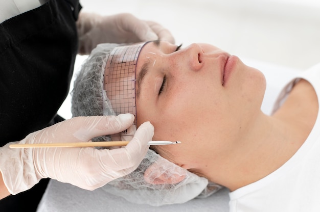 Mujer caucásica pasando por un procedimiento de microblading