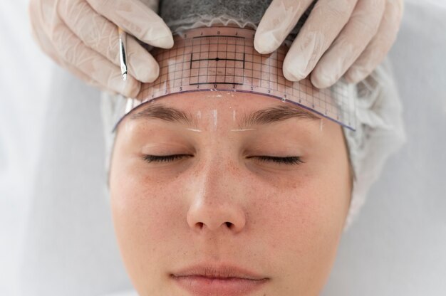 Mujer caucásica pasando por un procedimiento de microblading