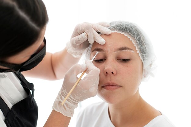 Mujer caucásica pasando por un procedimiento de microblading