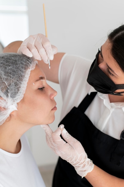 Mujer caucásica pasando por un procedimiento de microblading