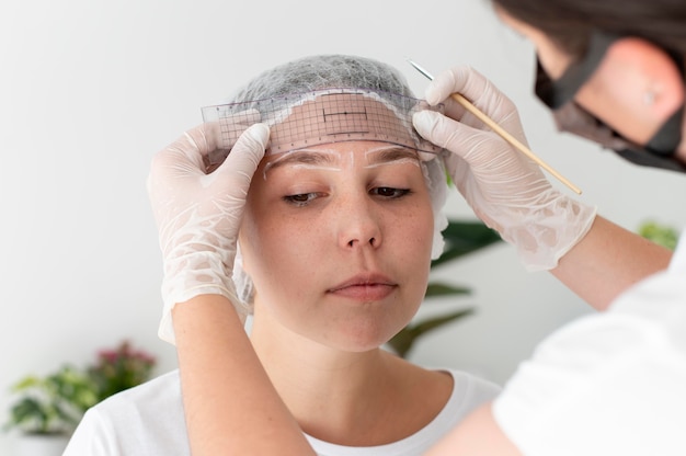 Mujer caucásica pasando por un procedimiento de microblading