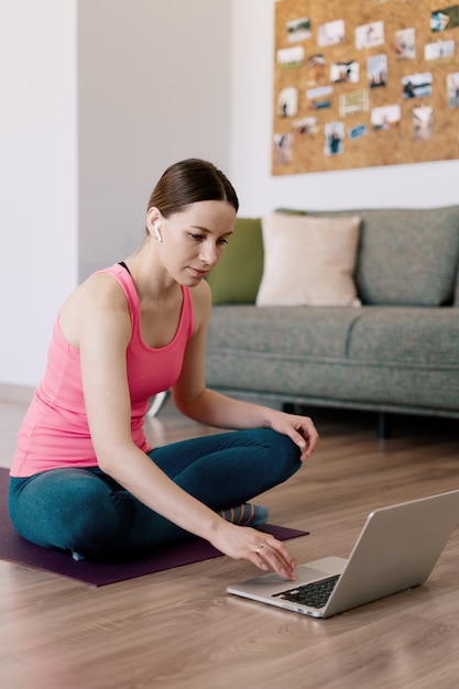 Mujer caucásica practicando yoga en casa