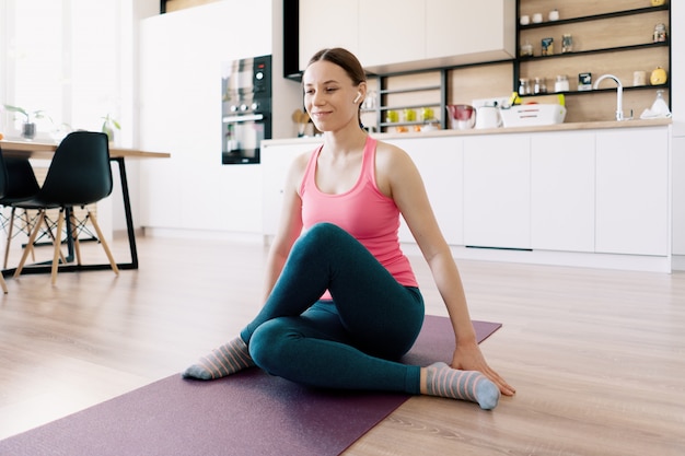 Mujer caucásica practicando yoga en casa