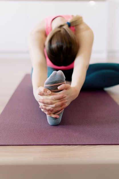 Mujer caucásica practicando yoga en casa