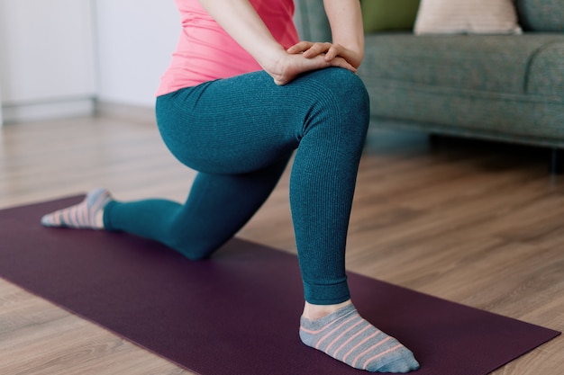 Mujer caucásica practicando yoga en casa