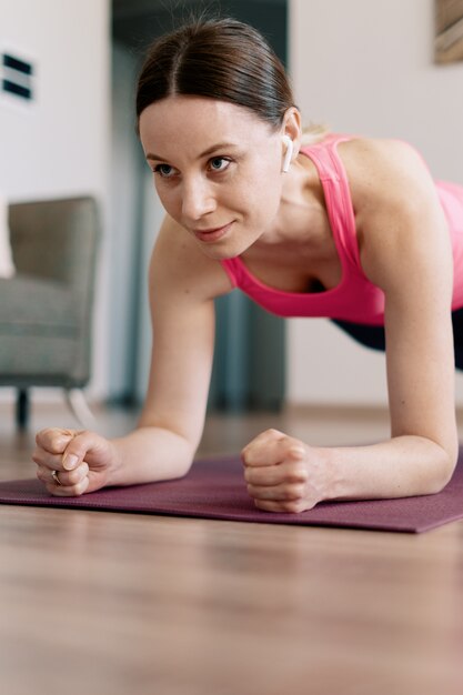 Mujer caucásica practicando yoga en casa