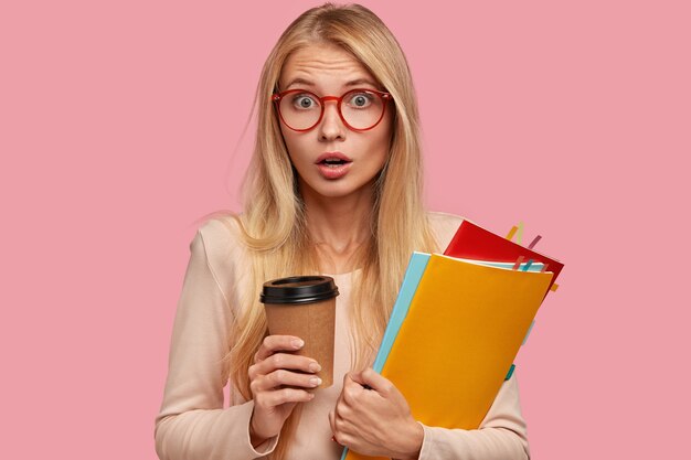 Una mujer caucásica rubia sorprendida y sorprendida viene en una lección de entrenamiento y se sorprende de tener una tarea inesperada