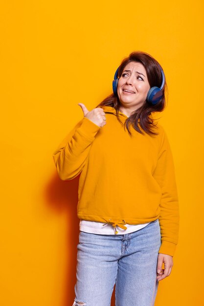 Mujer caucásica usando audífonos para escuchar la canción