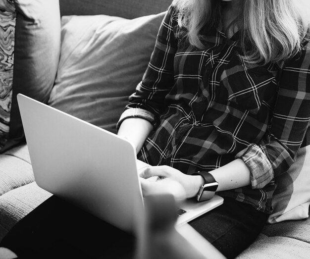 Mujer caucásica usando laptop en el sofá