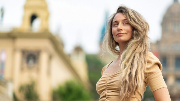 Mujer caucásica en vestido con vista de Barcelona al fondo, España