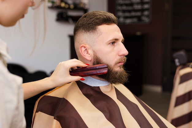 Foto gratuita mujer cepillando la barba de un hombre