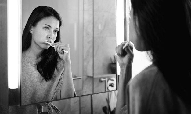 Mujer cepillándose los dientes por la mañana