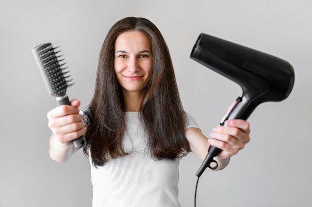 Foto gratuita mujer con cepillo y secador de pelo.