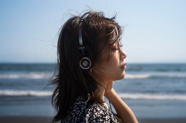 Foto gratuita mujer de cerca con auriculares en la playa