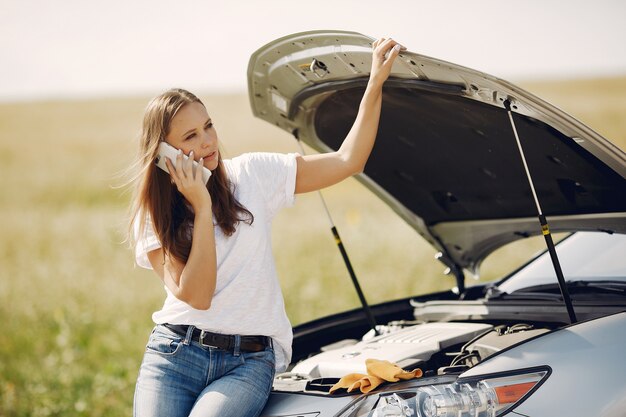 Mujer cerca de un auto roto pide ayuda