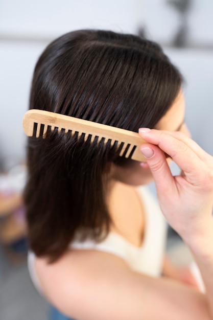 Mujer de cerca cepillándose el pelo