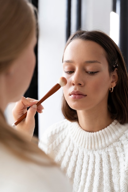 Mujer de cerca con pincel de maquillaje