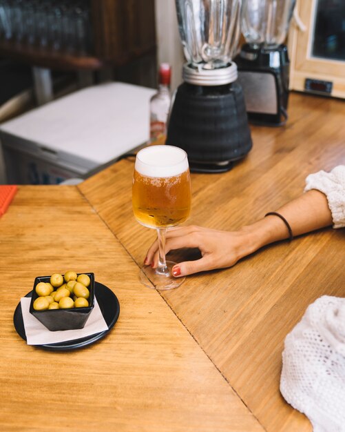 Mujer con cerveza y aceitunas