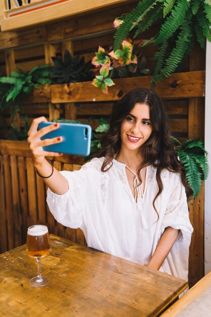 Mujer con cerveza haciendo un selfie