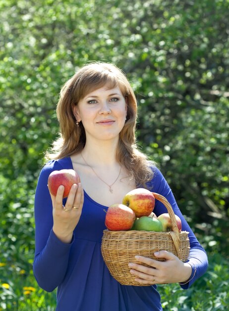 Mujer con cestas de manzanas cosechadas