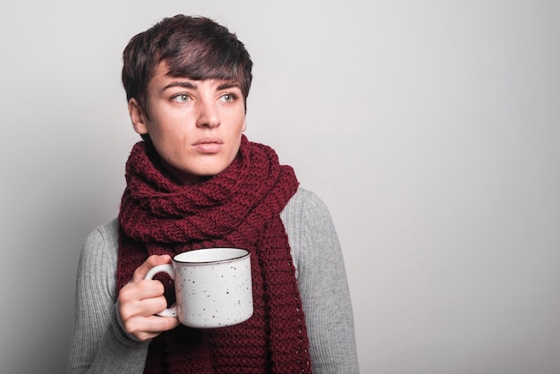 Foto gratuita mujer con chal alrededor de su cuello con taza de café