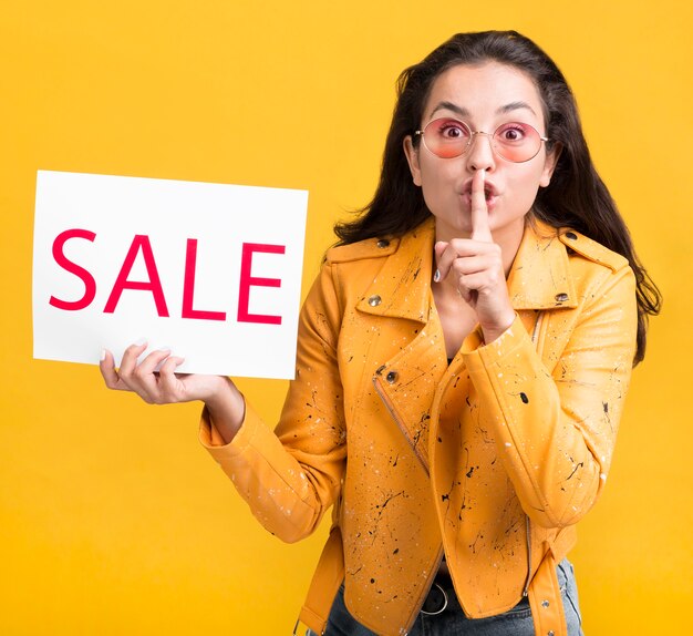 Mujer de chaqueta amarilla ventas gesto silencioso