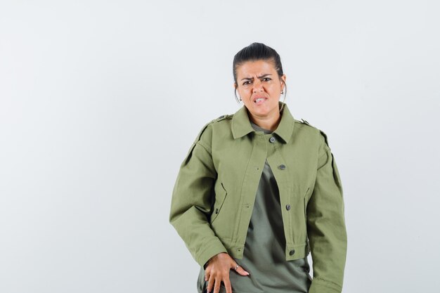 Mujer con chaqueta, camiseta mirando al frente y mirando preocupada