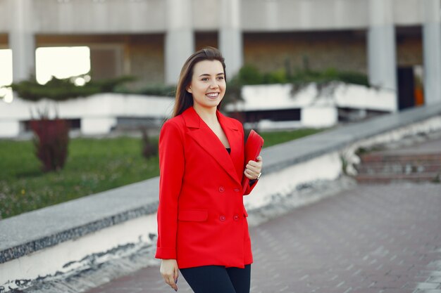 Foto gratuita mujer con chaqueta roja usando una tableta