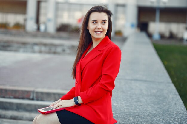 Mujer con chaqueta roja usando una tableta