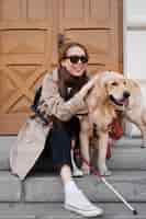 Foto gratuita mujer ciega sonriente con tiro completo de perro de servicio