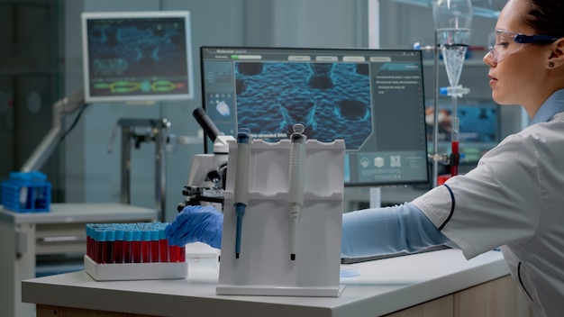 Mujer científica sentada en laboratorio con tecnología química