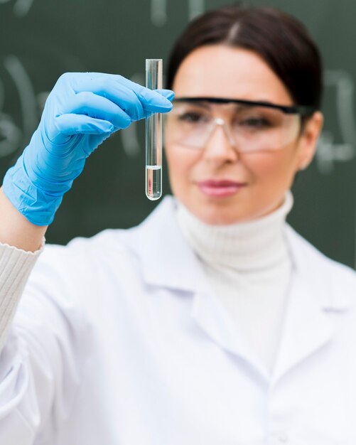 Mujer científico mirando el tubo de laboratorio