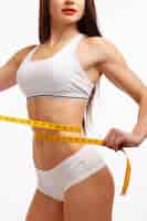 Foto gratuita mujer con una cinta métrica midiendo la cintura