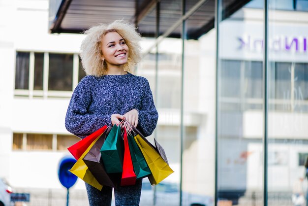 Mujer cliente con bolsas en la ciudad