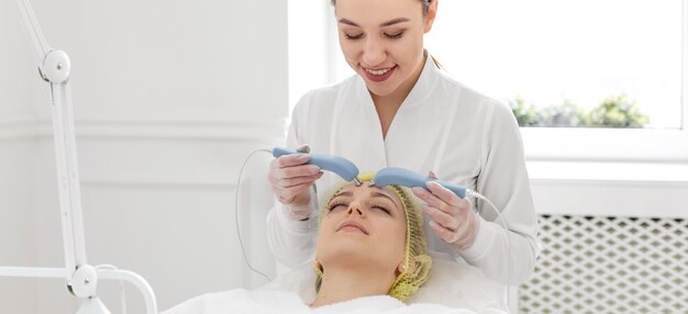 Mujer en la clínica de belleza para tratamiento facial