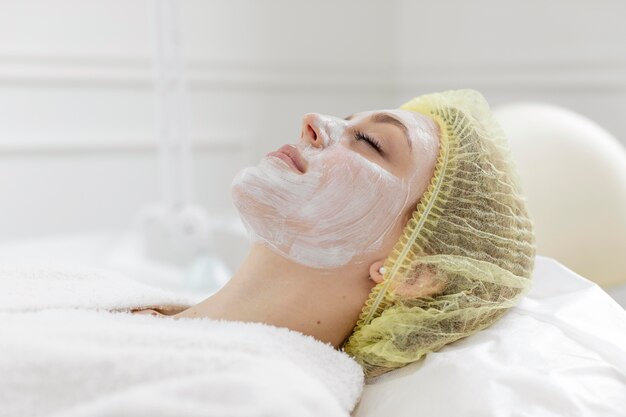 Mujer en la clínica de belleza para tratamiento facial