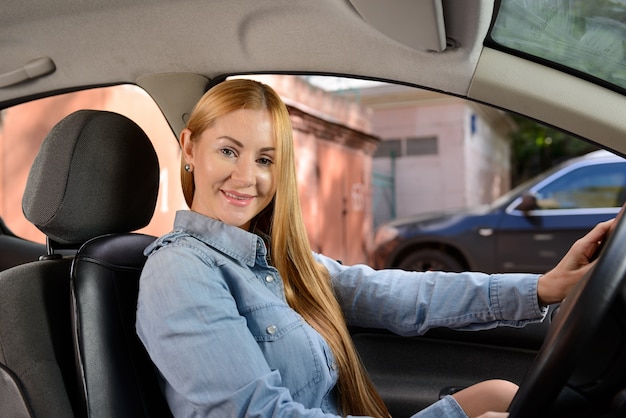 Mujer en coche con cojín de asiento de masaje