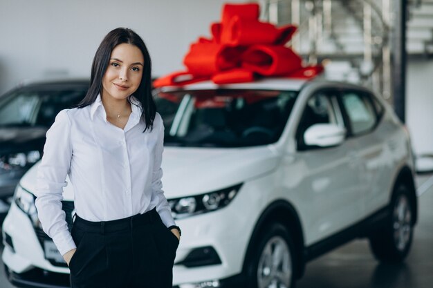 Mujer en el coche con gran lazo rojo