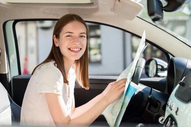 Mujer en el coche con mapa para viaje