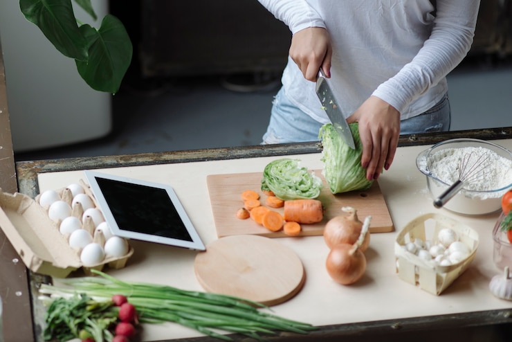 Foto gratuito mujer en cocina cortando algo