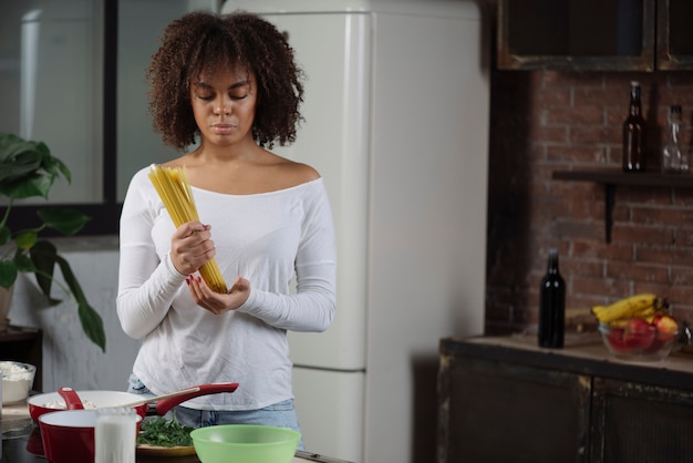 Mujer en cocina con espagueti