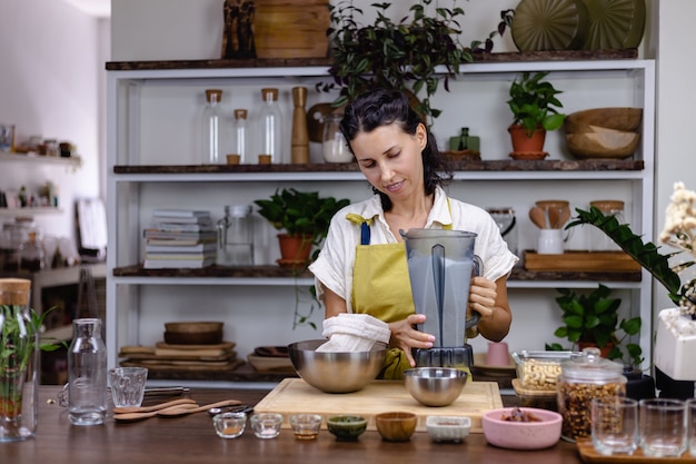 Mujer en la cocina con el proceso de elaboración de pudín de chía