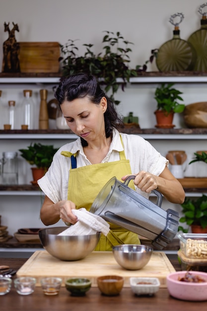 Mujer en la cocina con el proceso de elaboración de pudín de chía